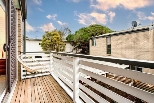 a balcony with a chair on a wooden deck at The River Nook on Hurst in Ocean Grove