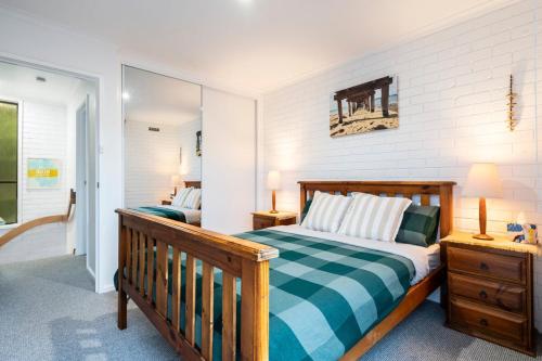 a bedroom with a wooden bed and a mirror at The River Nook on Hurst in Ocean Grove