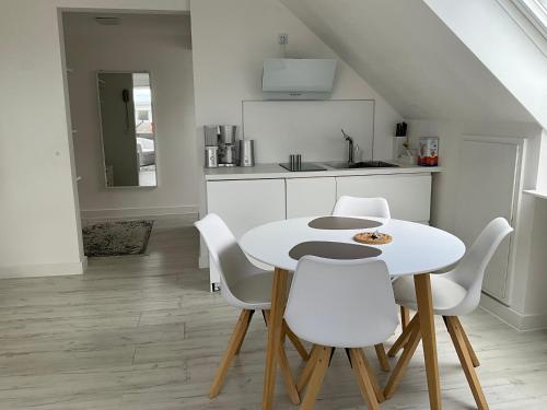 eine Küche mit einem weißen Tisch und weißen Stühlen in der Unterkunft City Apartment gegenüber vom Kurhaus in Freudenstadt