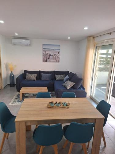 un salon avec un canapé bleu et une table dans l'établissement Calanques de Sormiou, à Marseille