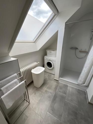 ein Dachgeschossbad mit Waschmaschine und Fenster in der Unterkunft City Apartment gegenüber vom Kurhaus in Freudenstadt