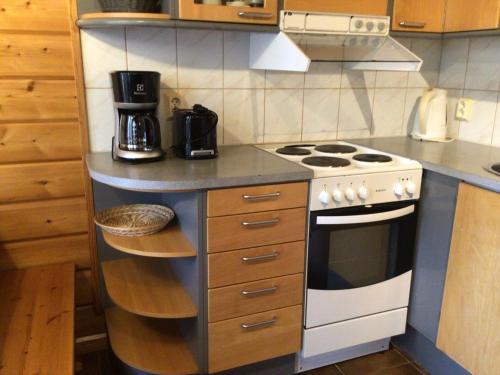 a kitchen with a stove and a counter top at Kolin country club 6pax in Hattusaari