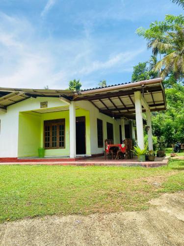 a house with a green and white at Hiriketiya Lima Homestay in Dickwella