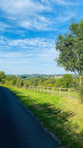 a road with a fence on the side of a field at The Loft at Crown Cottage in Clifton upon Teme