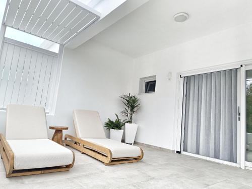 two chairs in a living room with a window at DelMar Suites Syros in Finikas