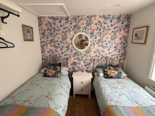 a bedroom with two beds and a mirror at North Laine Sunny Cottage - PARKING available in Brighton & Hove
