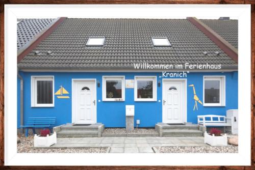 a blue building with two white doors at Ferienhaus Kranich in Pruchten