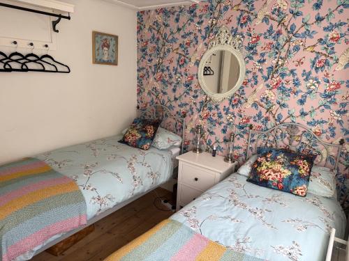 a bedroom with two beds and a mirror at North Laine Sunny Cottage - PARKING available in Brighton & Hove