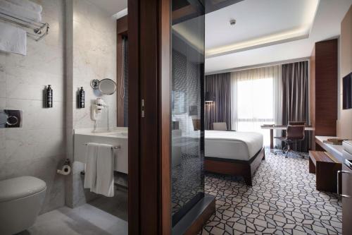 a hotel bathroom with a bed and a shower at Grand Harilton Otel in Istanbul