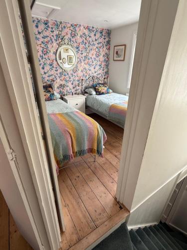 a small bedroom with two beds and a hallway at North Laine Sunny Cottage - PARKING available in Brighton & Hove