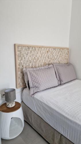 a bedroom with a bed with a headboard and a table at Angel's Petit House in Triovasálos