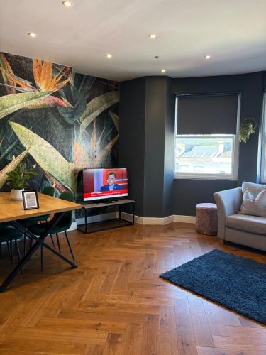 a living room with a couch and a television at Cosy flat with sea View in Brighton & Hove