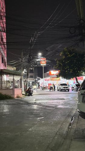 an empty city street at night with cars parked at 94Home Donmuang in Bang Khen