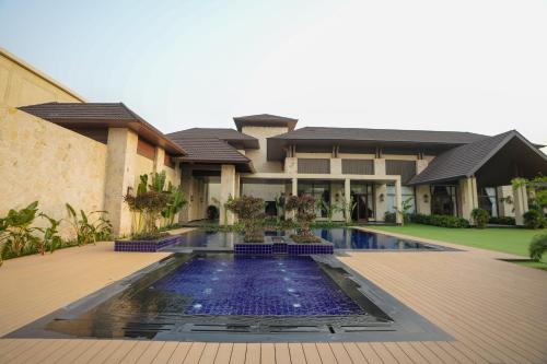 a house with a swimming pool in front of it at Noura Chandigarh - The Green Escape in Balluāna