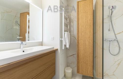 ein weißes Badezimmer mit Waschbecken und Dusche in der Unterkunft 2 pièces vue mer Nice ouest in Nizza