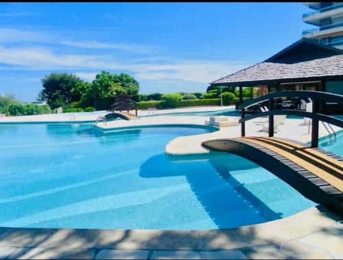 une grande piscine avec de l'eau bleue dans l'établissement 2 pièces vue mer Nice ouest, à Nice
