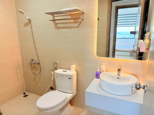 ein Badezimmer mit Toilette, Waschbecken und Spiegel in der Unterkunft Love Family Homestay, Nera Garden Apartment Huế in Thôn Văn Dương
