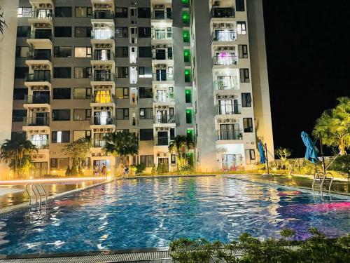 ein Schwimmbad vor hohen Gebäuden in der Nacht in der Unterkunft Love Family Homestay, Nera Garden Apartment Huế in Thôn Văn Dương