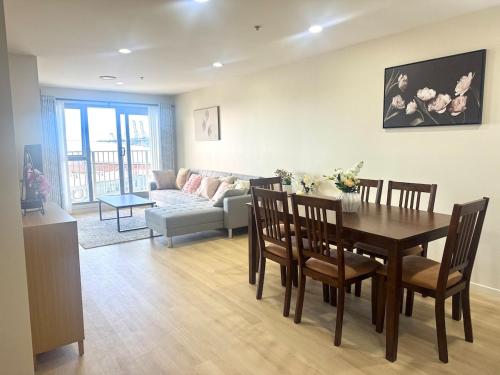 a dining room and living room with a table and chairs at Luxury Penthouse 2 bd 2 bth 2 carparks Pool in Auckland