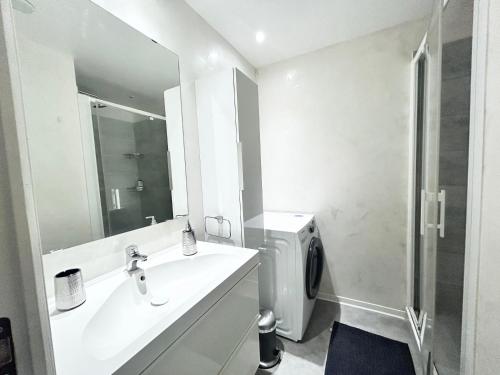 une salle de bain blanche avec un lavabo et une douche dans l'établissement Océan - 6 pers Hyper centre, au pied de la plage, à Saint-Raphaël