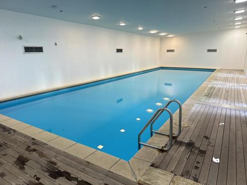 a large swimming pool with blue water in a room at Luxury Penthouse 2 bd 2 bth 2 carparks Pool in Auckland