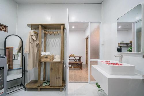 ein Badezimmer mit einem weißen Waschbecken und einer Badewanne in der Unterkunft Small Home Corner - Peaceful place in the heart of Da Lat in Da Lat