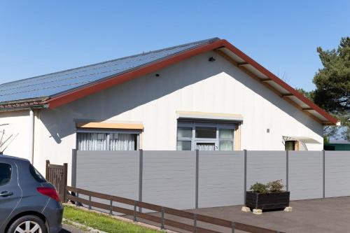 a white house with a fence in front of it at Loft touristique 3 étoiles in Dannemarie