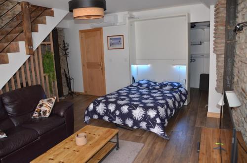 ein Wohnzimmer mit einem Bett und einer Couch in der Unterkunft Maison de village palau del vidre in Palau-del-Vidre
