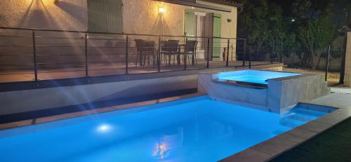 une piscine avec des lumières bleues dans une arrière-cour dans l'établissement Villa Piscine vue dégagée, à Montaren-et-Saint-Médiers