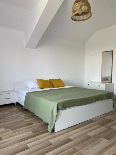 a white bedroom with a bed and a mirror at Casa Livia in Tuzla