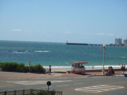 une vue sur la plage et l'océan avec un food truck dans l'établissement Les Mouettes, à Les Sables-dʼOlonne