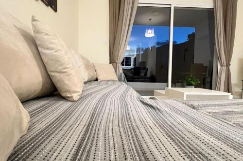 a bedroom with a bed with pillows and a window at 113 Apartment, A 2-Bedroom Escape in Paphos City
