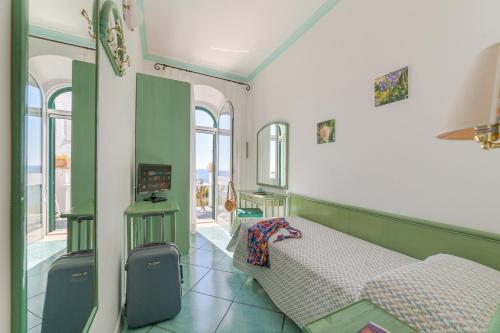 a bedroom with a bed in a room with windows at Appartamenti Casa del Sole in Ischia