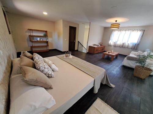a large bed in a living room with a couch at Finca para eventos y complejo rural Mi Cobijo in Fuentelviejo