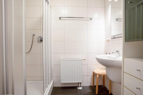 ein weißes Badezimmer mit Waschbecken und Dusche in der Unterkunft Villa Eden Binz Typ 3 / Apartment 12 in Binz