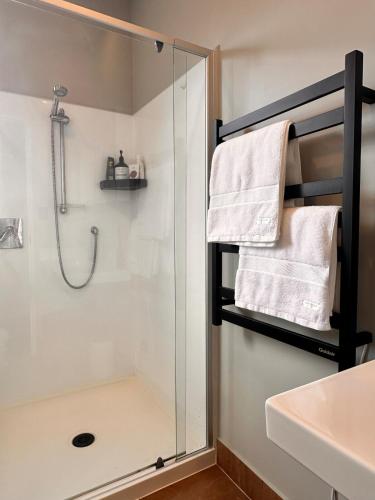 a bathroom with a shower and a glass shower stall at Stylish Freemans Bay Stay in Auckland