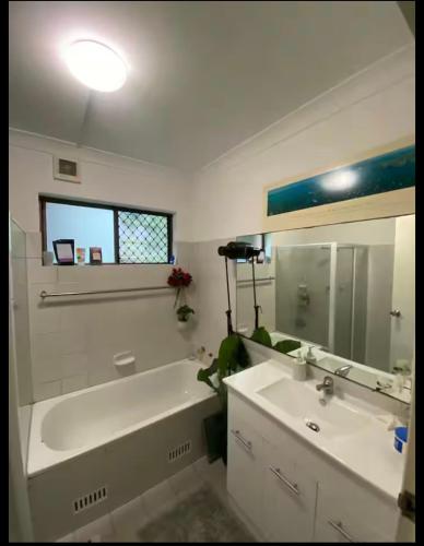a bathroom with a sink and a tub and a mirror at Hidden Gem North Sydney in Sydney