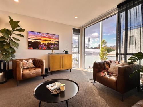 a living room with two couches and a table at Stylish Freemans Bay Stay in Auckland