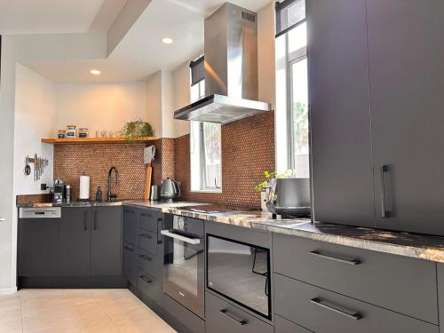 a kitchen with gray cabinets and a counter top at Stylish Freemans Bay Stay in Auckland