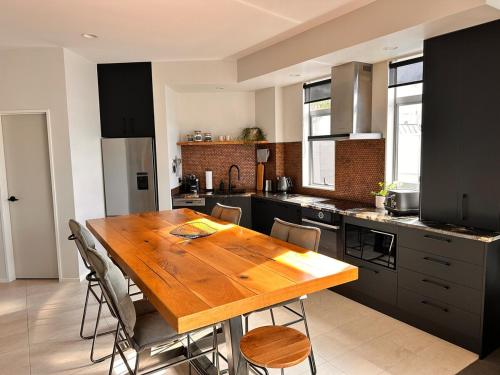 a kitchen with a wooden table and some chairs at Stylish Freemans Bay Stay in Auckland