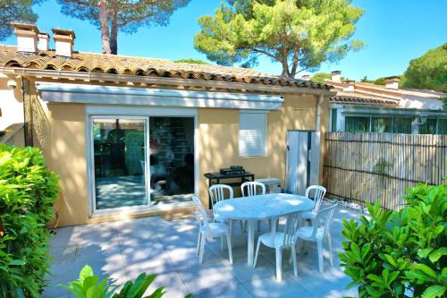 カップ・ダグドにあるMaison de la Pinède, villa 7 pers + terrasseの家の前にテーブルと椅子が置かれたパティオ