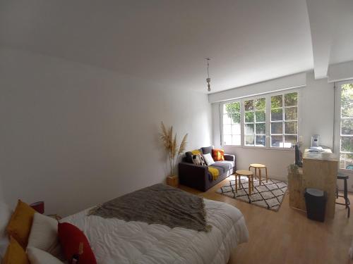 une chambre avec un lit, un canapé et une fenêtre dans l'établissement Studio avec jardin, à Talence