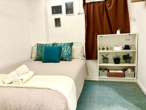 a bedroom with two beds with blue pillows at Cozy Bachelor In PmQ with Rooftop in Hong Kong