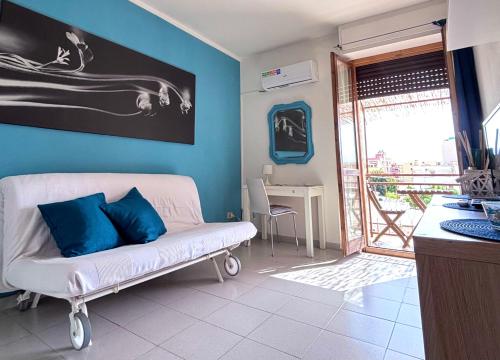a living room with a white couch and a blue wall at Blue apartment, Alghero, near beaches in Alghero