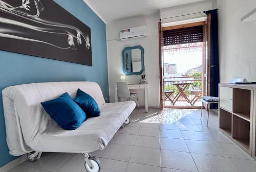 a living room with a white couch with blue pillows at Blue apartment, Alghero, near beaches in Alghero