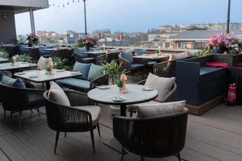 a restaurant with tables and chairs on a roof at Ramada Encore by Wyndham Siliguri Sevoke Road in Siliguri