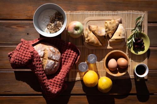 a table with bread and eggs and fruit on it at eumelia organic agrotourism farm in Goúvai