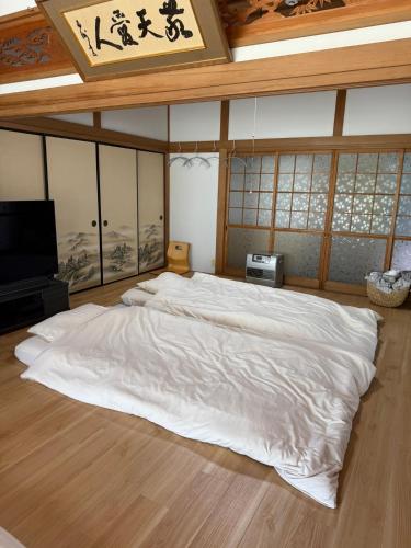 a bedroom with a large white bed in a room at いろどり荘 ドッグラン併設 露天風呂付き in Inokuchi