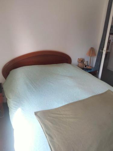 une chambre avec un lit avec une tête de lit en bois dans l'établissement Maisonnette agréable, à Saint-Malo