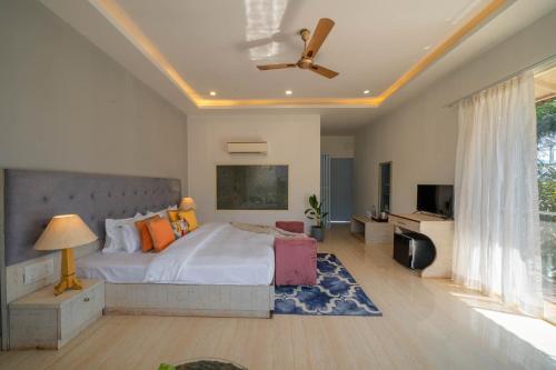 a bedroom with a large bed and a large window at Perfectstayz Koko Maya 5 mins walk to beach in Morjim